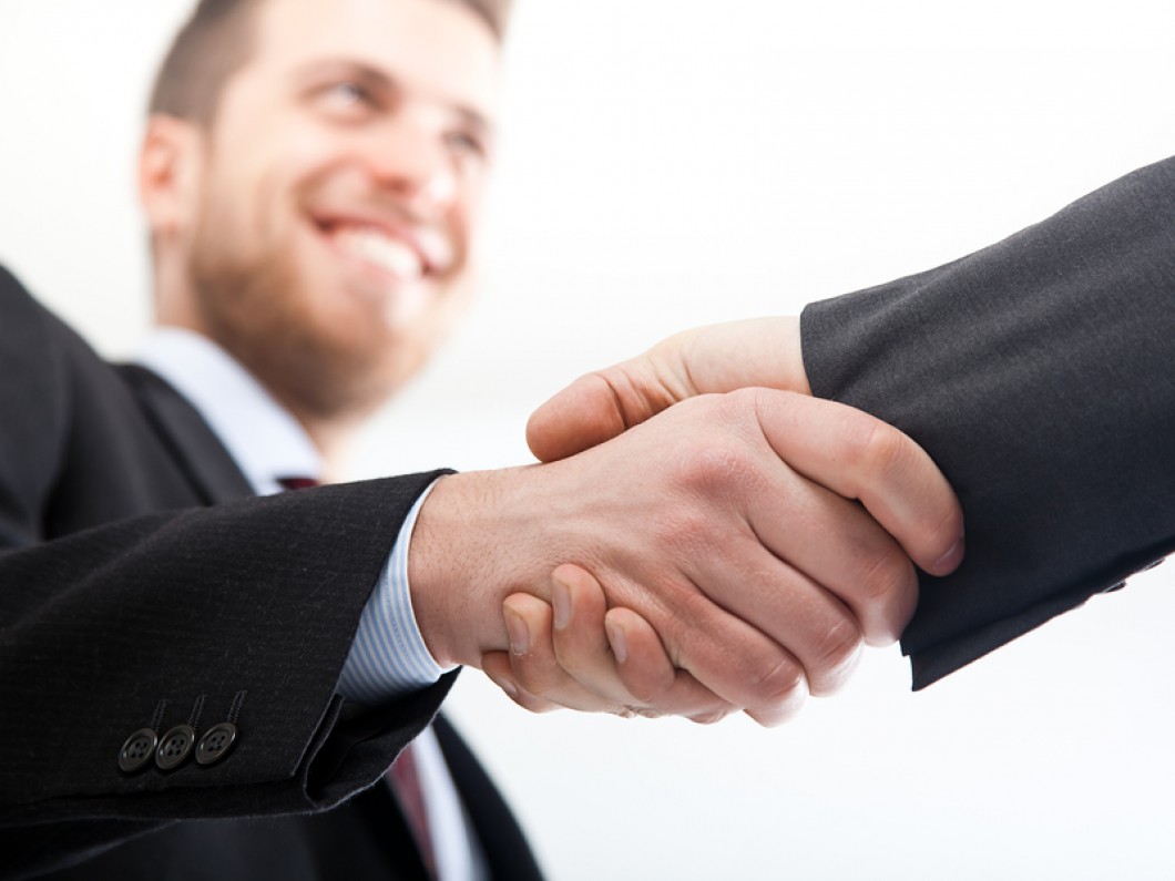 man shaking hands with someone and smiling